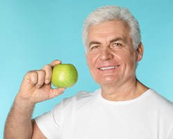 a dentures patient holding an apple