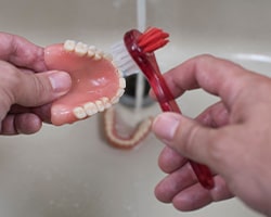 Dentures patient in Houston washing their prosthetic