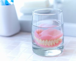 Dentures patient in Houston soaking their prosthetics