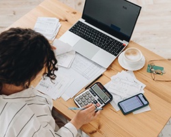 Woman sitting at her desk with a calculator and various documents