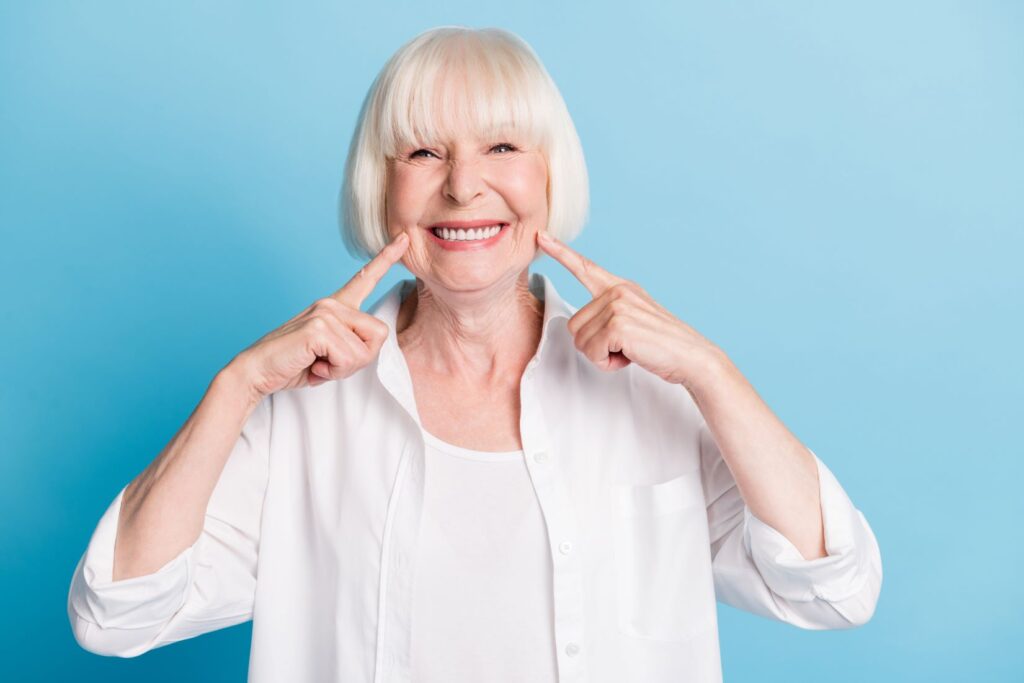 A woman pointing to her mouth.