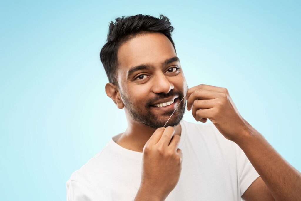 A man flossing his teeth